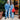 A stylish duo rocks bold double denim: he in a utility jacket, jeans, and loafers; she in a sleeveless vest over ripped jeans with a red bag.